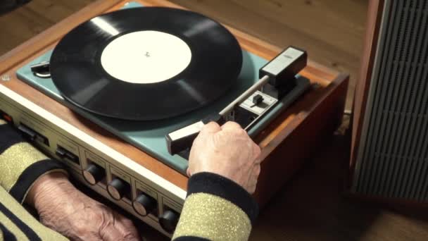 Oude vrouw luisteren vinyl record op speler — Stockvideo