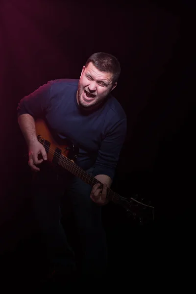 Portret van een bebaarde muzikant met gitaar — Stockfoto