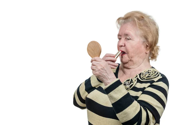 Пожилая женщина гримируется — стоковое фото