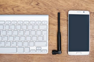 Telefon, anten ve masanın üstünde klavye