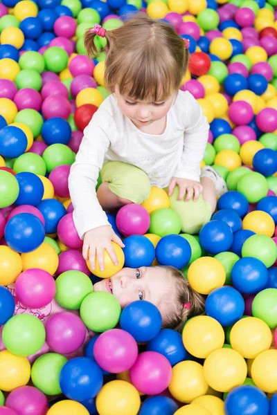 Los niños juegan en bolas coloridas — Foto de Stock