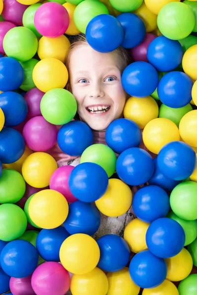Улыбающийся ребенок в цветных шарах — стоковое фото