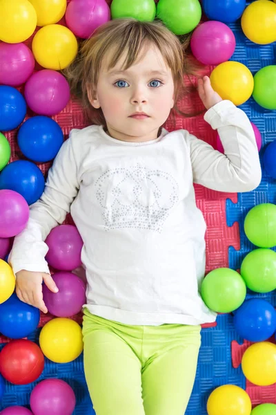 Enfant sérieux dans des boules colorées — Photo