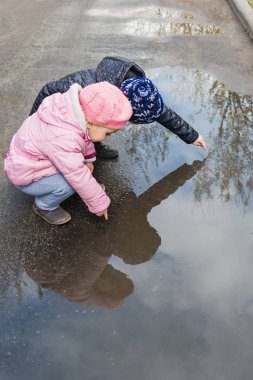 Bir su birikintisine oynayan kızlar