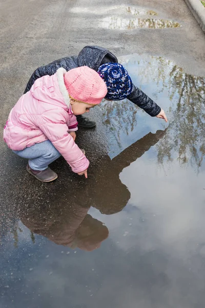 Girls playing in a puddle — Stock Photo, Image
