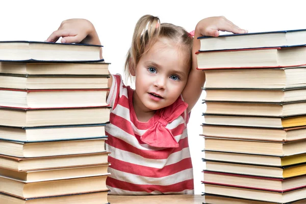 Ребенок между стопками книг — стоковое фото