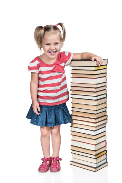 Ребенок прислонился к стопке книг — стоковое фото