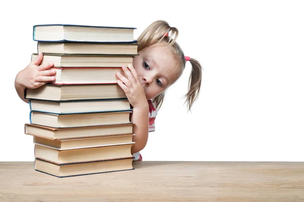 Kind schaut hinter den Büchern hervor — Stockfoto