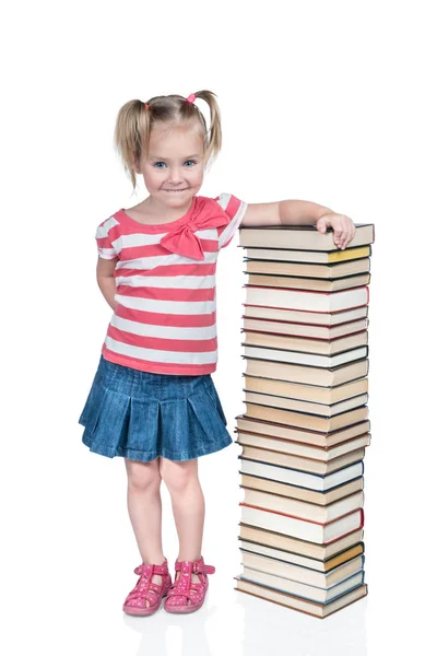 Meisje op een hoge stapel boeken — Stockfoto