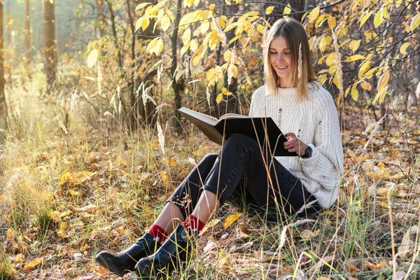 Kvinna läser en bok i skogen — Stockfoto