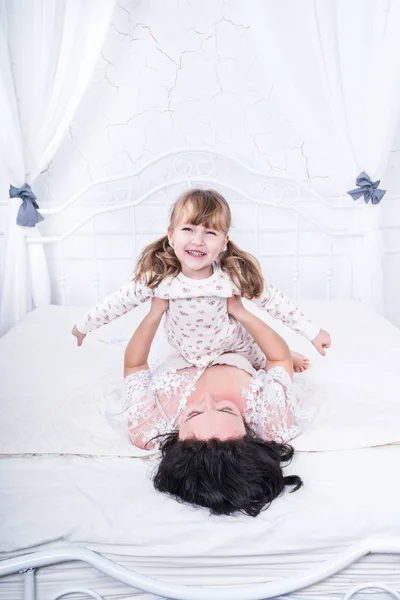 Anne kızı yatakta yükseltir — Stok fotoğraf