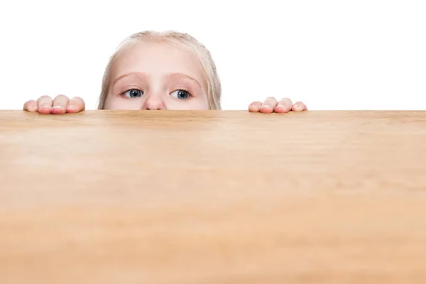 Niño mira desde debajo de la mesa —  Fotos de Stock