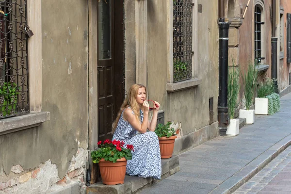 Zamyšlená žena sedící na ulici — Stock fotografie