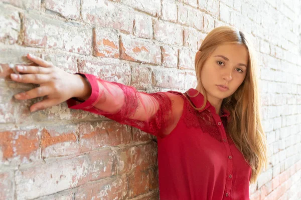 Dívka u zdi z červených cihel — Stock fotografie