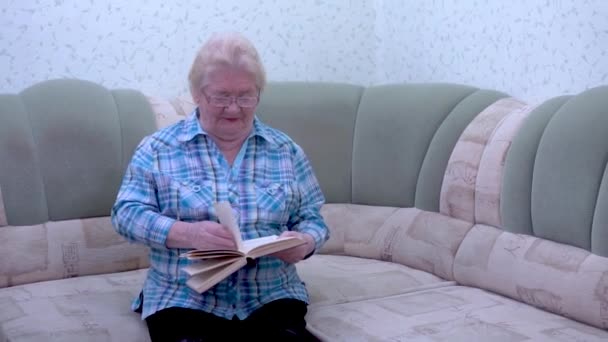 Стара жінка читає книгу — стокове відео