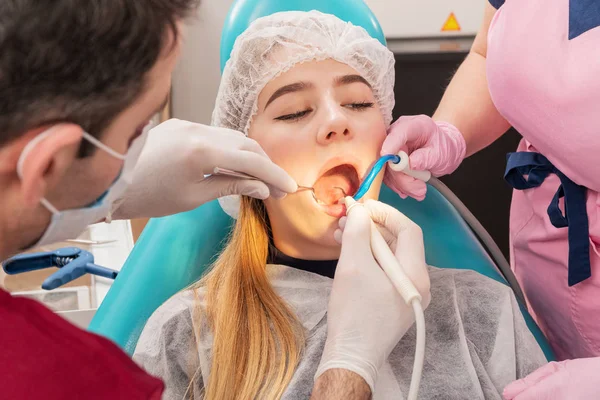 Dentista limpia los dientes al paciente con agua — Foto de Stock