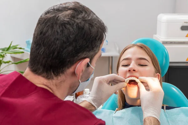 Dentista pone dientes en su paciente — Foto de Stock