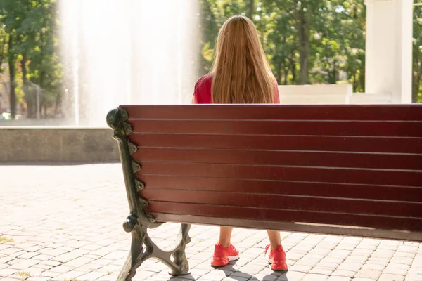 Dziewczyna siedzi przy fontannie — Zdjęcie stockowe
