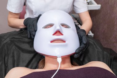 beautician puts mask on patient