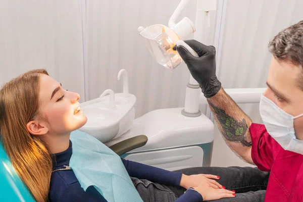Dentista ilumina la boca del paciente — Foto de Stock