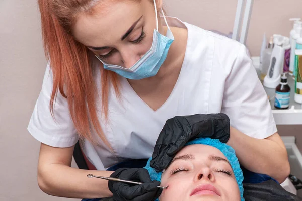 Esteticista limpia la cara del paciente — Foto de Stock