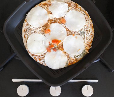 Mutfak ocağında pizza.