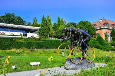 LAUSANNE, SWITZERLAND - August 7 ,2019.  Sculpture in the Olympic Park Lausanne, on the shore of  Lake Leman (Lake Geneva ). Here is Olimpic Museum ,largest archive of Olympic Games in the world. clipart