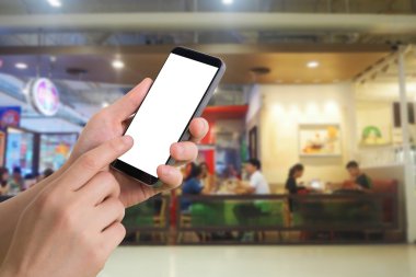 insan eli tutun ve smartphone bulanık insanlar yemek yemek Kortu arka plan boş ekran ile dokunmatik.