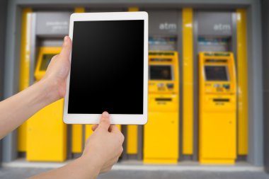 insan eli tutun ve bulanık bankamatikler arka plan boş ekran ile akıllı telefon, tablet, cep telefonu tarama parmak izi