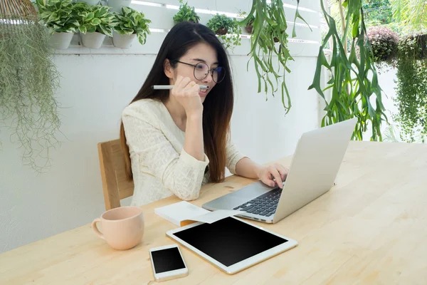 office place in  tree garden at home, Wood table with Asian woma