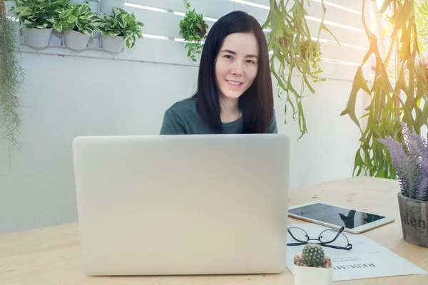 Office table with laptop and blank screen on laptop, Asian woman