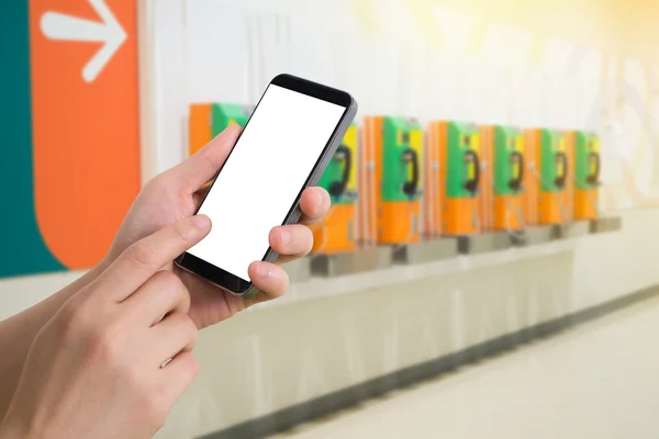 Mano humana y el teléfono inteligente táctil con pantalla en blanco en borrosa —  Fotos de Stock