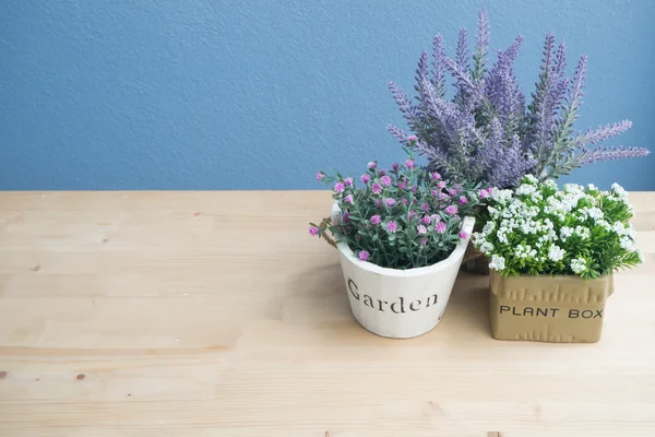 Vaso da fiori su tavolo di legno e sfondo di cemento blu . — Foto Stock