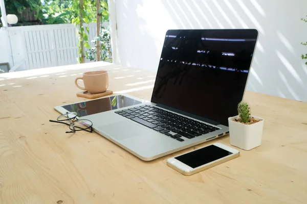 Офісний стіл з квіткою кактуса на горщику, порожній екран на ноутбуці — стокове фото