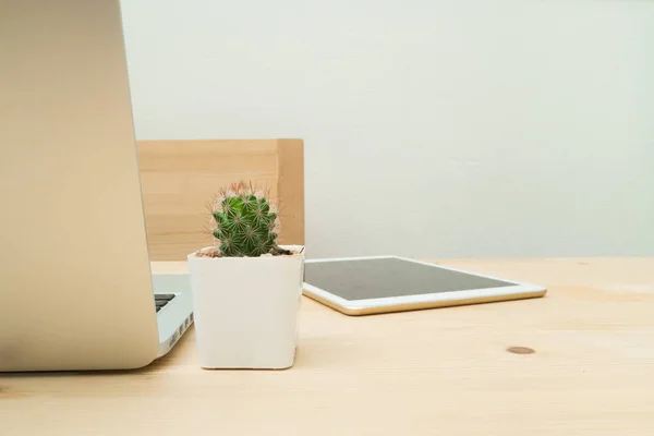 Офісний стіл з квіткою кактуса на горщику і ноутбуці, планшет . — стокове фото