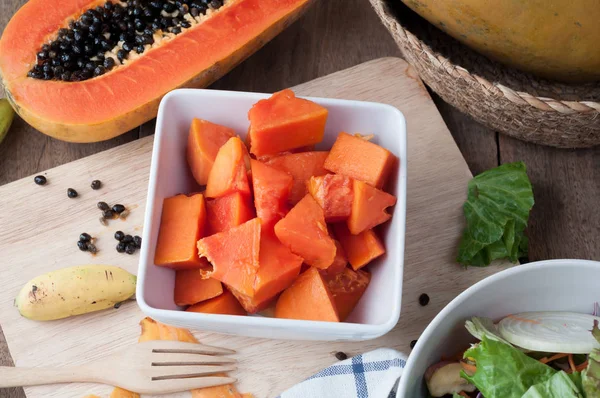 Kitchen table with sliced fresh papaya fruit on wood cutting boa — Stock Photo, Image