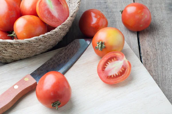 Kitchen table with slice fresh tomatoes on wood basket. — Stock Photo, Image