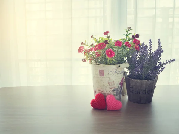 Mesa de oficina con rosa rosa flor en maceta y corazón rojo sh — Foto de Stock