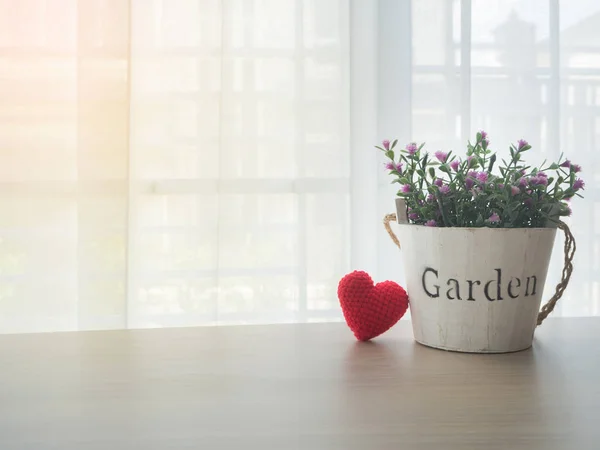 Mesa de oficina con rosa rosa flor en maceta y corazón rojo sh — Foto de Stock