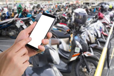 insan eli tutun akıllı telefon, tablet, cep telefonu bulanık Park motosiklet üzerinde.