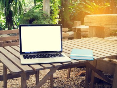 Ofis Masaları boş ekran dizüstü ve mavi kapak defter kağıdı Park ile.