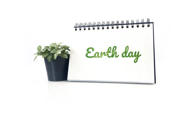 Green earth day text on Desktop calendar and small garden tree o — Stock Photo, Image