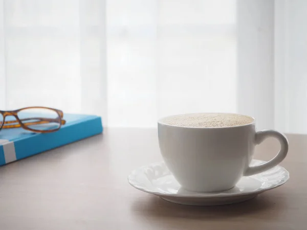 Mesa de escritório de madeira com xícara de café latte e óculos modernos — Fotografia de Stock