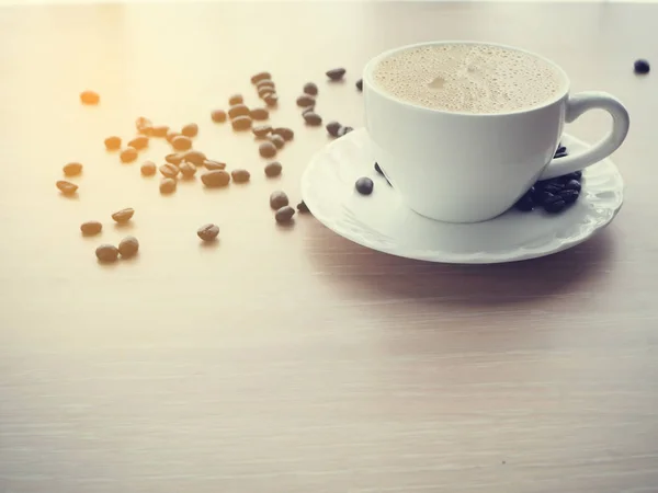 Taza de café blanco de café con leche y café frijol, tono cálido . — Foto de Stock