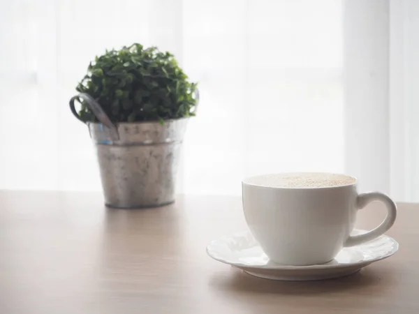 Дерев'яний стіл з чашкою білої кави лате кави, дрібний деревний гарнір — стокове фото