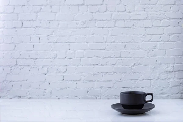 Taza de té sobre fondo de textura de pared de ladrillo blanco . — Foto de Stock
