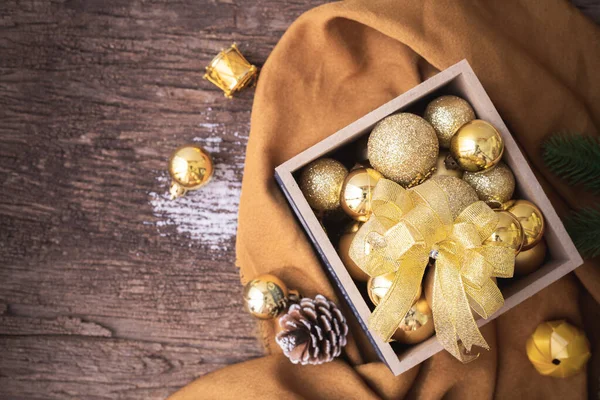 Holztisch mit Weihnachtsdekoration mit Goldkugel auf Schachtel, — Stockfoto