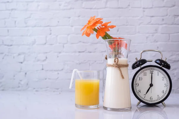 Mesa de desayuno con vaso de zumo de naranja y botella de leche. — Foto de Stock