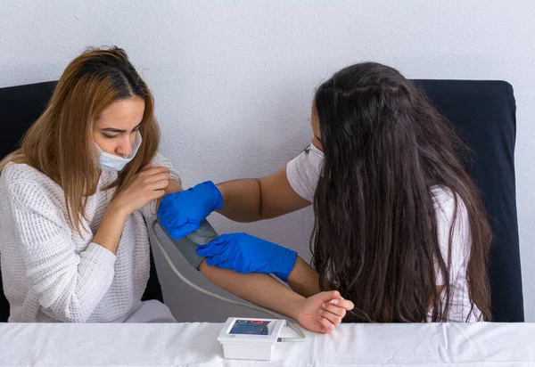 Patient with asthma and respiratory problems being treated by a nurse in the hospital. Nurse taking the patient\'s blood pressure. Coronavirus pandemic.