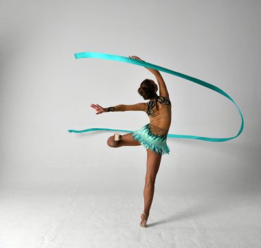 Mavi takımlı bir jimnastikçi dans ediyor.